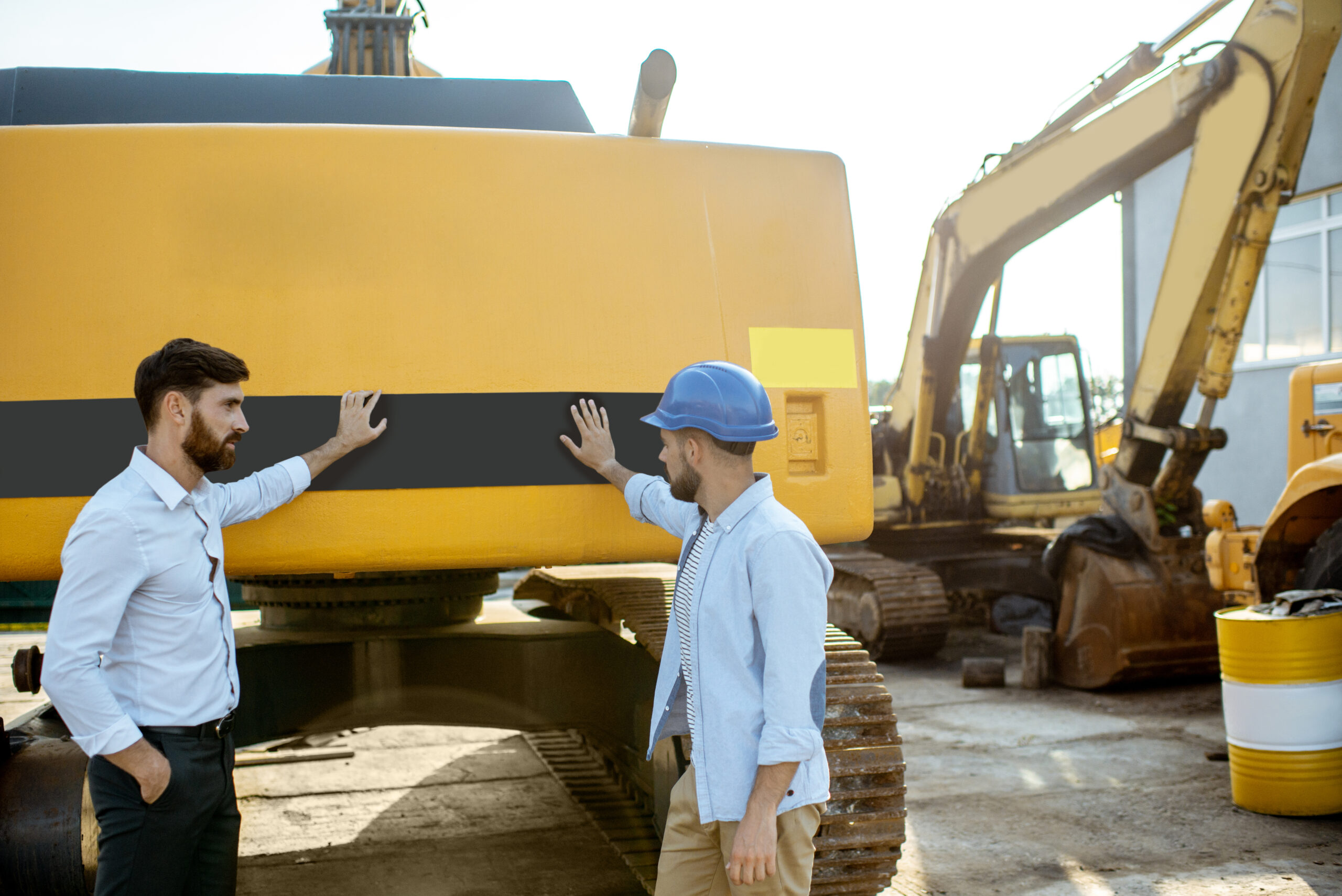 Builder with a sales consultant at the shop with heavy machinery